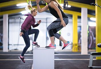 Image showing athletes working out  jumping on fit box