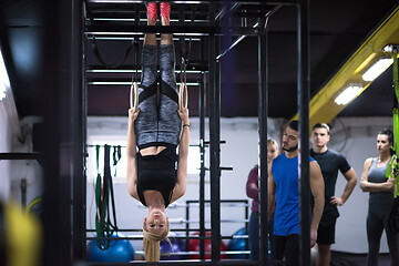 Image showing woman working out with personal trainer on gymnastic rings