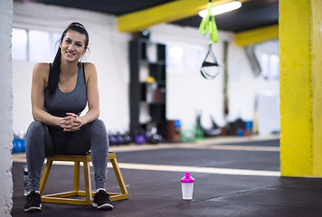 Image showing young athlete woman sitting and relaxing