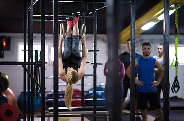 Image showing woman working out with personal trainer on gymnastic rings