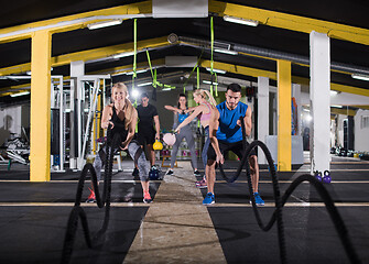 Image showing sports couple doing battle ropes cross fitness exercise