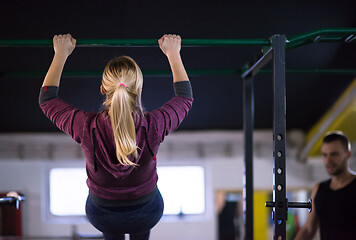 Image showing woman doing pull ups on the horizontal bar