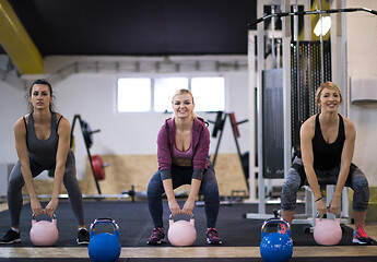 Image showing athletes doing exercises with kettlebells