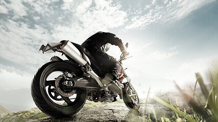 Image showing Biiker on highway, riding around a curve with a motion blur toned