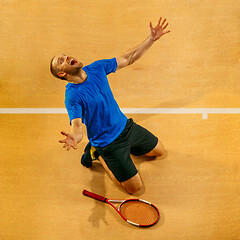 Image showing Portrait of a handsome male tennis player celebrating his success at court