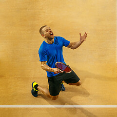 Image showing Portrait of a handsome male tennis player celebrating his success at court