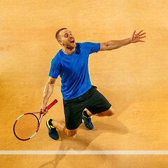 Image showing Portrait of a handsome male tennis player celebrating his success at court