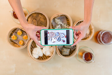 Image showing Top view of cellphone taking photo on dim sum