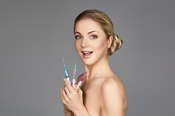 Image showing beautiful girl holding syringes