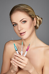 Image showing beautiful girl holding syringes