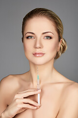 Image showing beautiful girl holding syringe