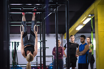 Image showing woman working out with personal trainer on gymnastic rings