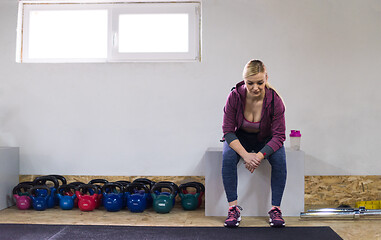 Image showing young athlete woman sitting and relaxing