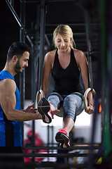 Image showing woman working out with personal trainer on gymnastic rings