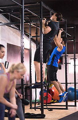 Image showing young athletes doing pull ups on the horizontal bar