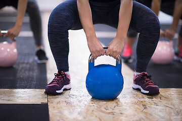 Image showing athletes doing exercises with kettlebells