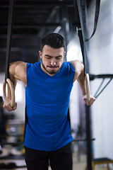 Image showing man working out pull ups with gymnastic rings