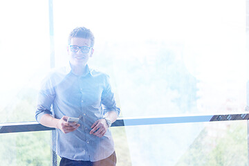 Image showing Businessman Standing In A Modern Building Near The Window With P