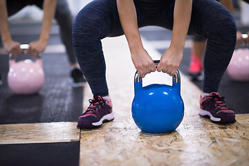 Image showing athletes doing exercises with kettlebells