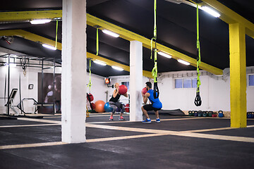 Image showing young athletes couple working out with medical ball