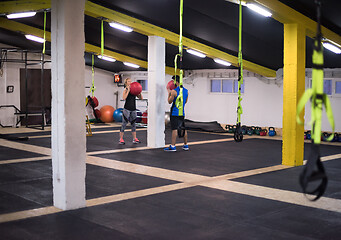 Image showing young athletes couple working out with medical ball