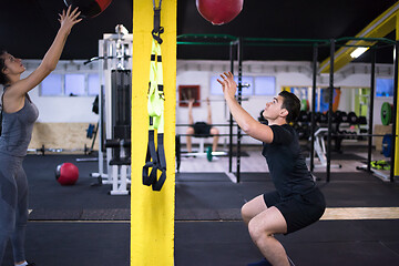 Image showing young athletes couple working out with medical ball