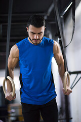 Image showing man working out pull ups with gymnastic rings