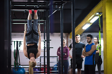 Image showing woman working out with personal trainer on gymnastic rings