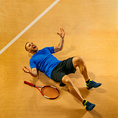 Image showing Portrait of a handsome male tennis player celebrating his success at court