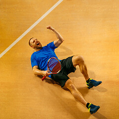 Image showing Portrait of a handsome male tennis player celebrating his success at court