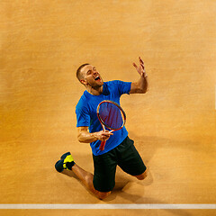 Image showing Portrait of a handsome male tennis player celebrating his success at court