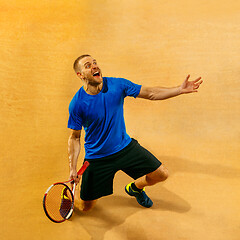 Image showing Portrait of a handsome male tennis player celebrating his success at court