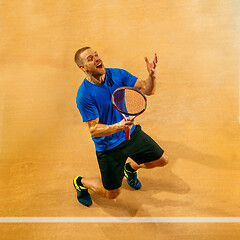 Image showing Portrait of a handsome male tennis player celebrating his success at court