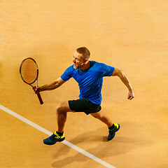 Image showing Portrait of a handsome male tennis player celebrating his success at court