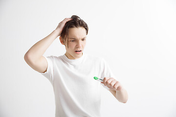 Image showing Upset man looking in pregnancy test. Frustrated model