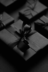 Image showing Black Christmas concept. Close up on elegant black matte wrapped gifts with ribbon.