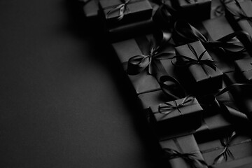 Image showing A pile various size black boxed gifts placed on stack. Christmas concept.