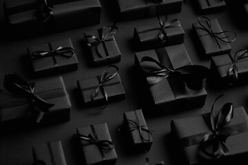 Image showing Elegant black Christmas theme. Wrapped gifts in black matte paper with ribbon