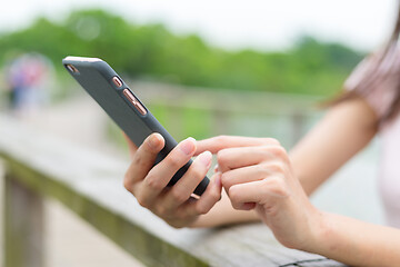 Image showing Woman touch on cellphone in park