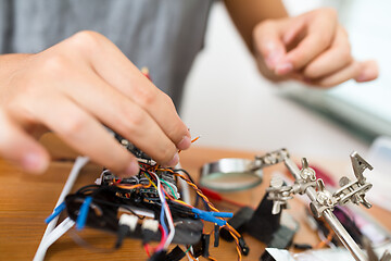 Image showing Man connecting the wire of flying drone