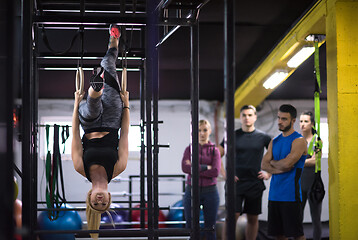 Image showing woman working out with personal trainer on gymnastic rings