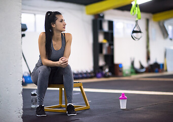 Image showing young athlete woman sitting and relaxing