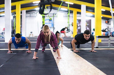 Image showing young healthy people doing pushups