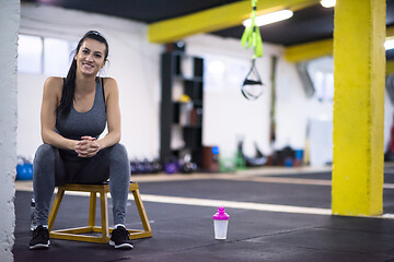 Image showing young athlete woman sitting and relaxing