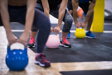 Image showing athletes doing exercises with kettlebells