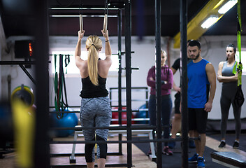 Image showing woman working out with personal trainer on gymnastic rings