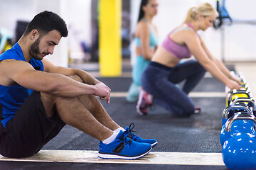 Image showing young athletes doing pushups with kettlebells