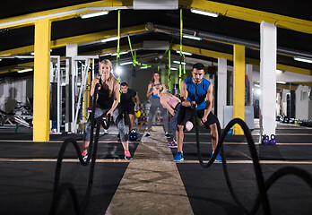 Image showing sports couple doing battle ropes cross fitness exercise