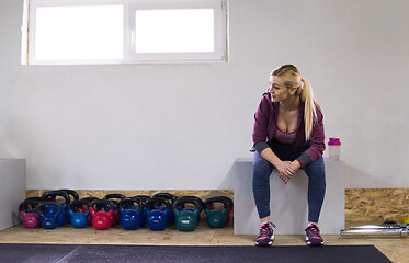 Image showing young athlete woman sitting and relaxing