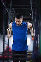 Image showing man working out pull ups with gymnastic rings